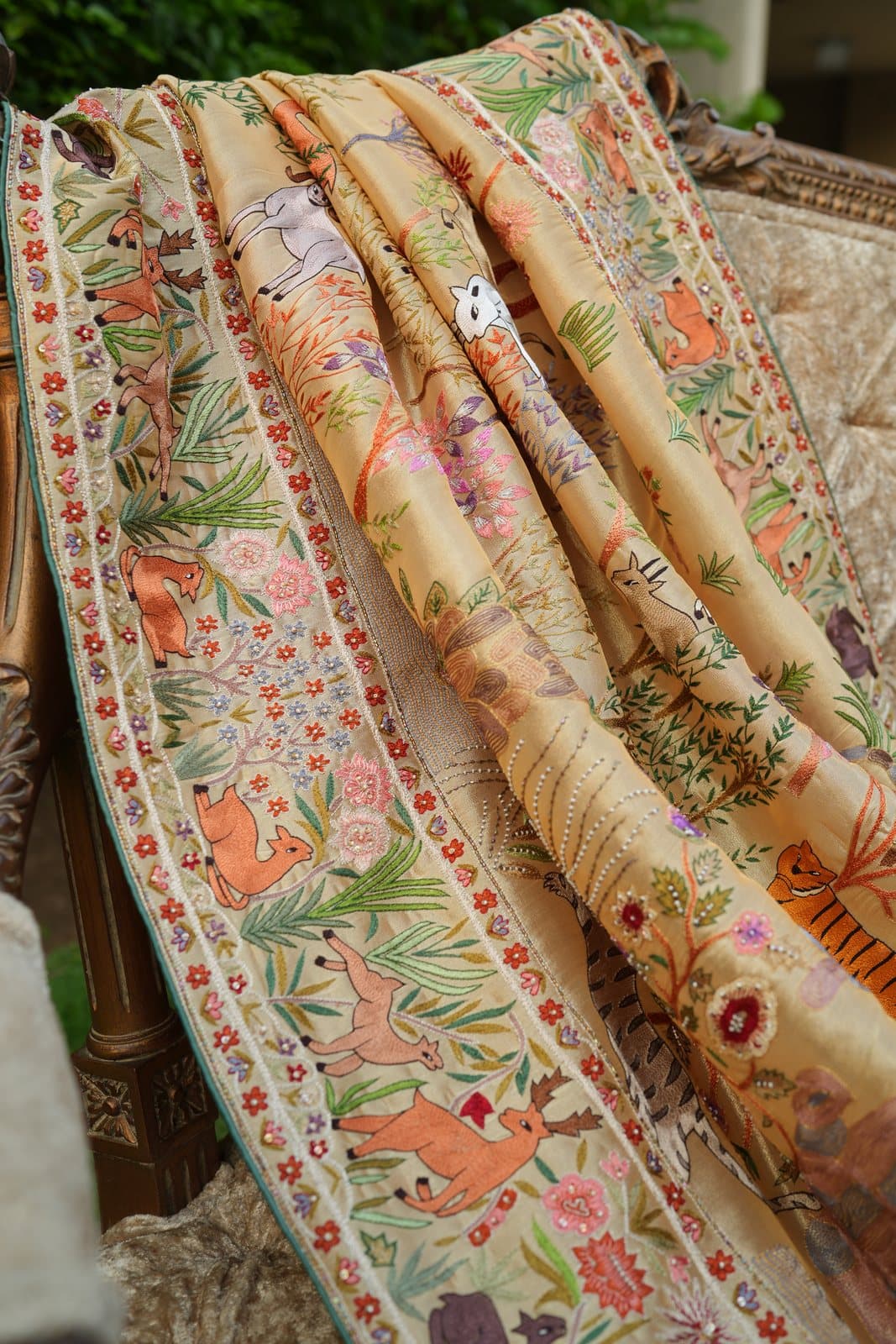 A close view of a shikargah shawl border, its hunting scene of deer and tigers worked in coloured silk.