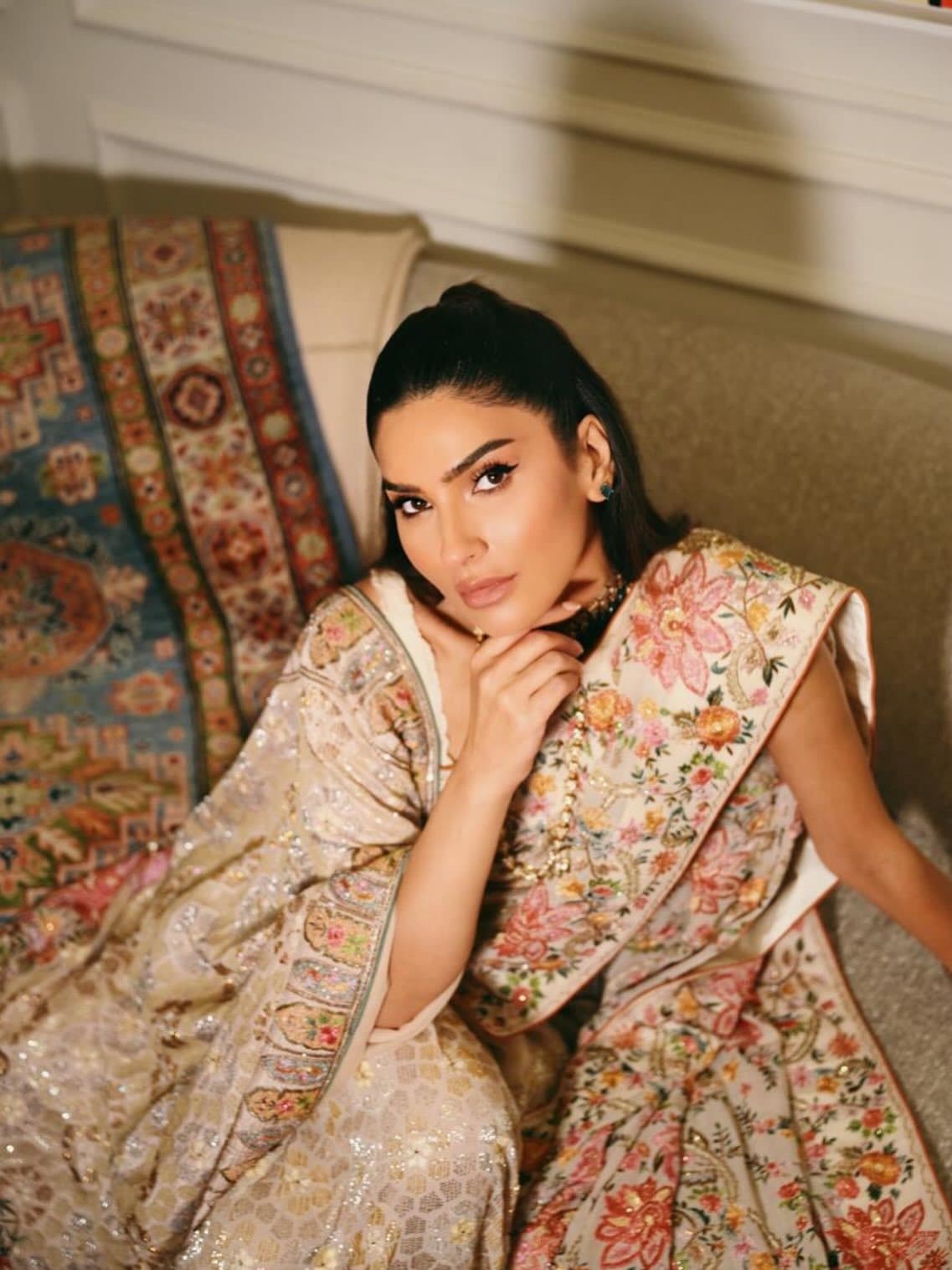 A client seated in an embroidered shawl, the work catching the light across her shoulder.