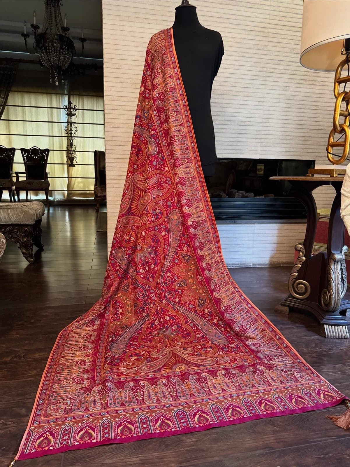 A fuchsia bridal shawl with a deep embroidered border, draped full-length over a mannequin.