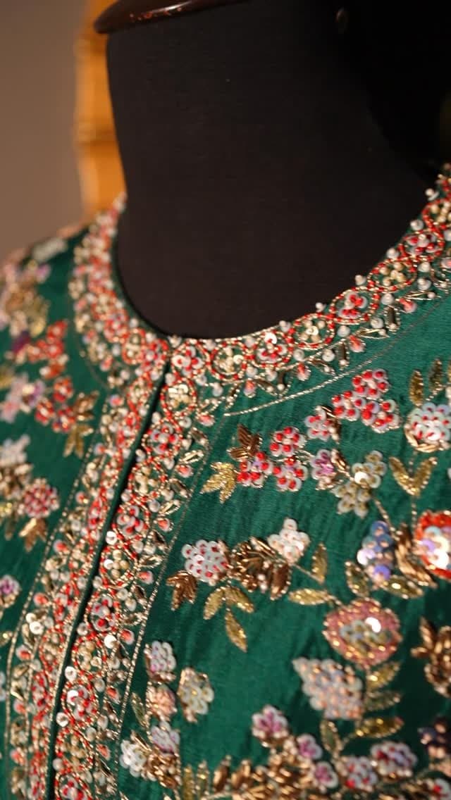 An emerald kurta with dense multicoloured embroidery across the placket and body.